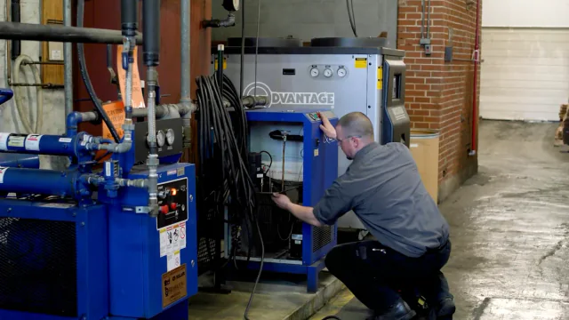 Technician servicing an industrial air dryer in a plant