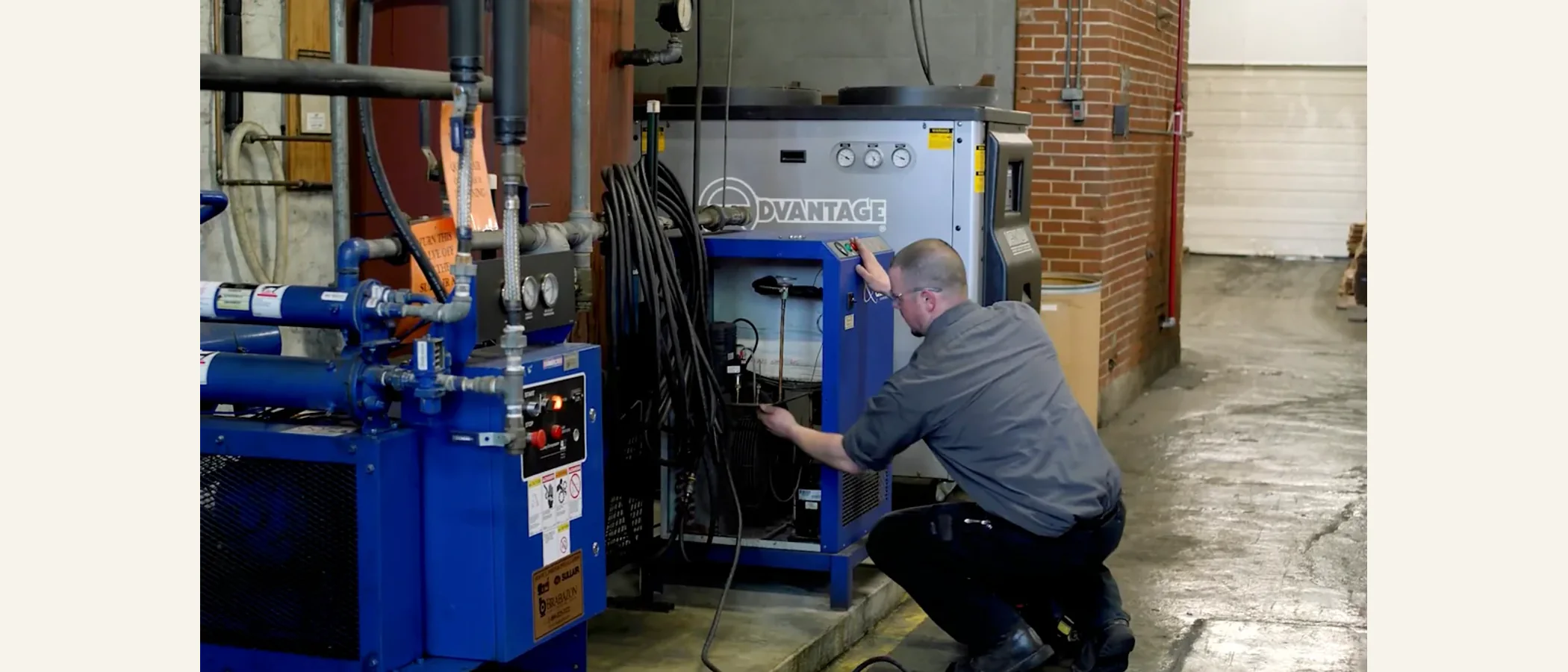 Technician servicing an industrial air dryer in a plant