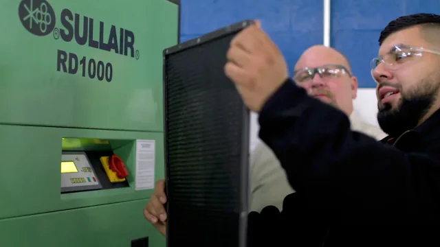 Technician inspecting a Sullair RD1000 dryer and filter
