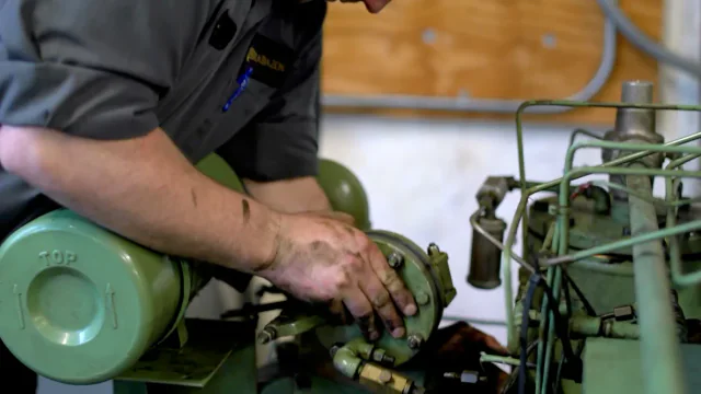 Technician repairing the mechanism of a reciprocating compressor