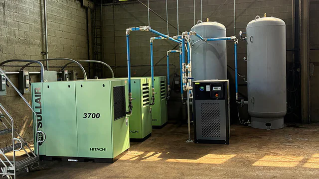 Industrial compressor installation with compressors and receiver tanks